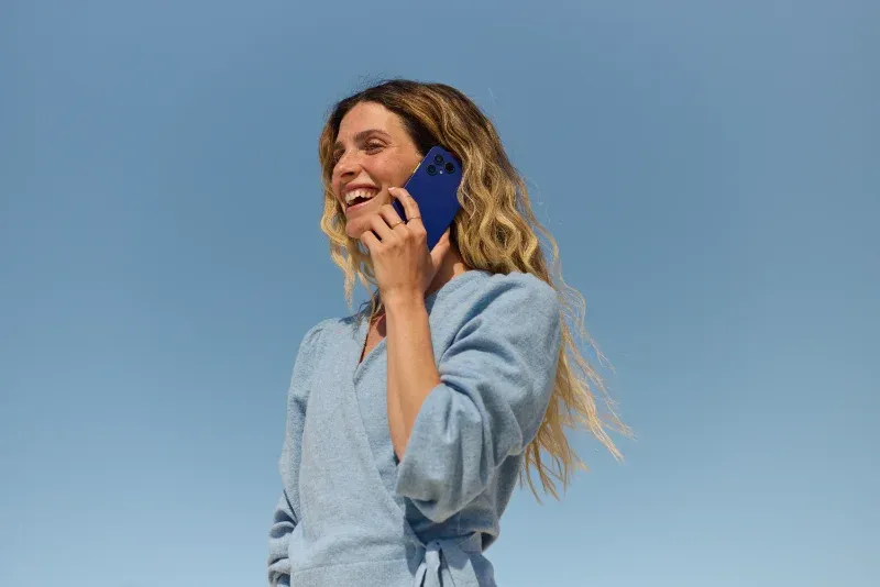 Eine Frau hält ein blaues Fairphone Gen. 6+ in der Hand