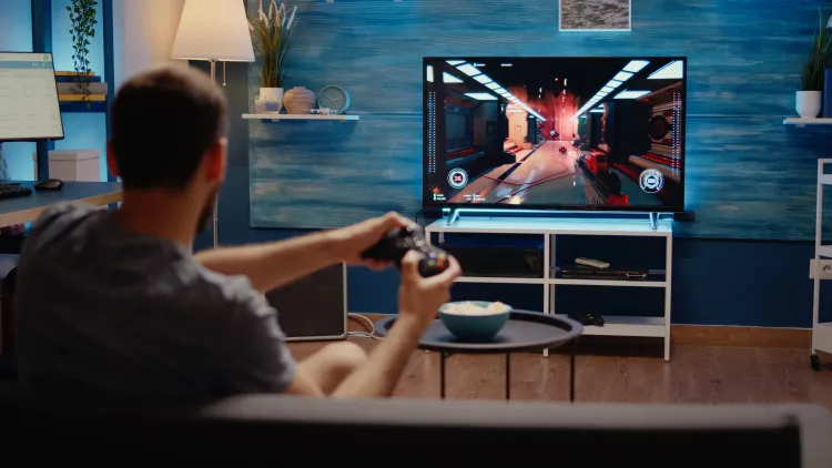 Gamer spielt ein Spiel, dass zu dunlklen Flächen auf dem Bildschirm führt.