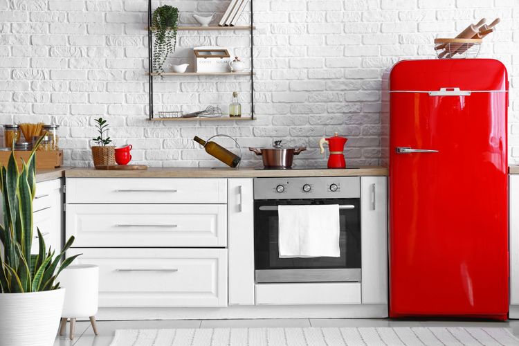 Roter Retro-Standkühlschrank in Küchenzeile mit Herd und weißem Küchenschrank