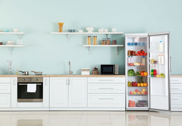 offener Kühlschrank mit frischen Lebensmitteln in weißer Einbauküche