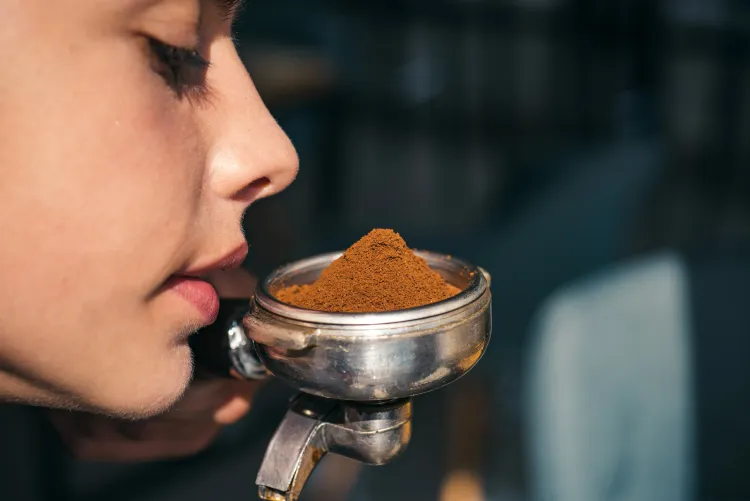 Person riecht an frisch gemahlenem Kaffeepulver