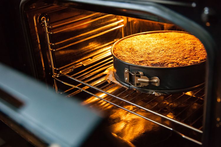 Blick ins Backrohr auf bald fertiggebackenen Kuchen in runder Kuchenform