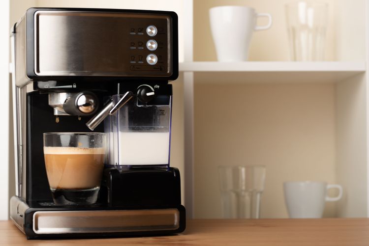 Kaffeevollautomat mit fertiger Tasser Kaffe und gefülltem Milchbehälter