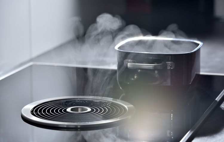 aktiver Kochfeldabzug saugt Dampf aus Kochtopf ab