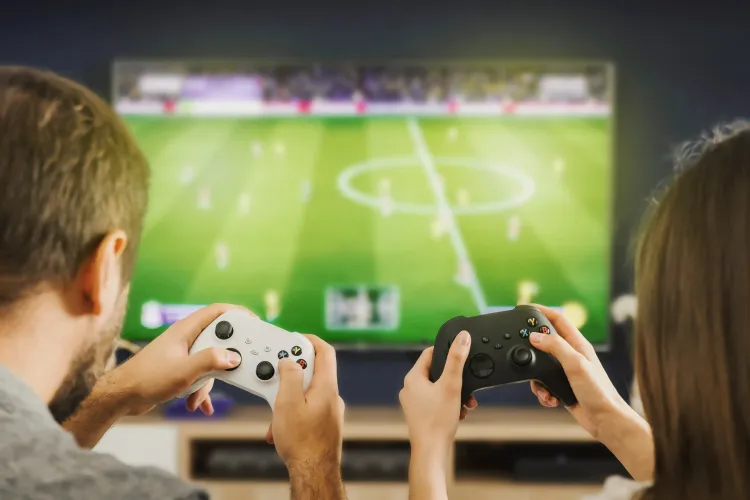 Zwei Spieler:innen beim Fußball zocken von hinten. 