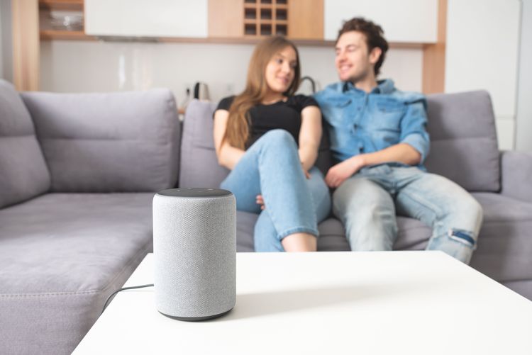 Pärchen auf Sofa mit Multiroom-Lautsprecher