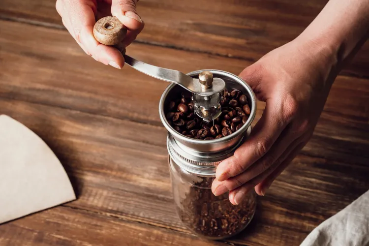 Hände bedienen manuelle Kaffeemühlen