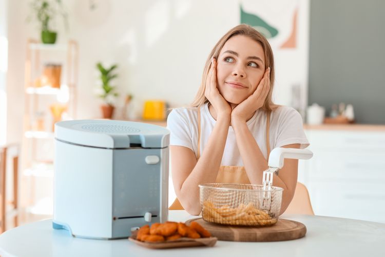 Person neben Fritteuse