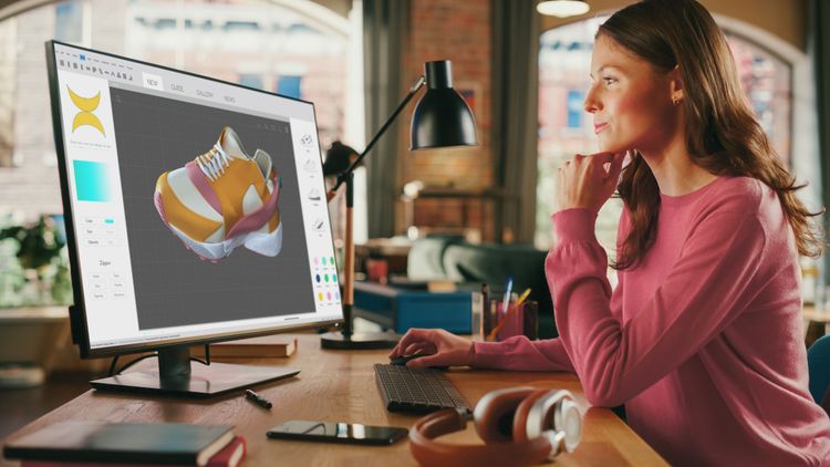 Frau arbeitet mit einem Design-Programm am PC.