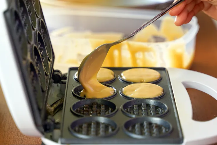 Person füllt Teig in Pancake Maker 