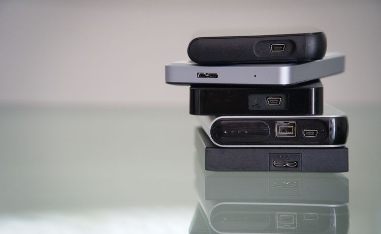 Fünf externe Festplatten aufeinander, Fokus auf die unterschiedlichen USB-Anschlüsse