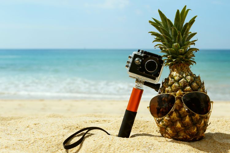 Ananas, Sonnenbrille und Action-Cam am Strand