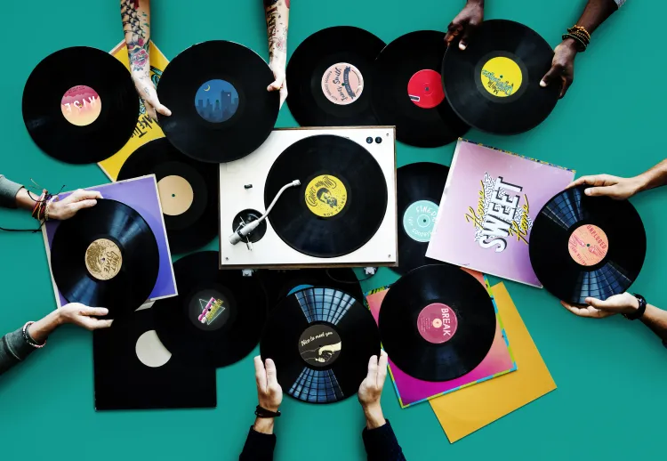 Mehrere Hände präsentieren Vinyl-Schallplatten
