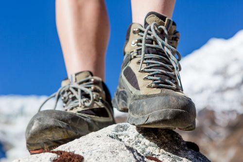 Nahaufnahme mit Bergschuhen auf Fels stehend