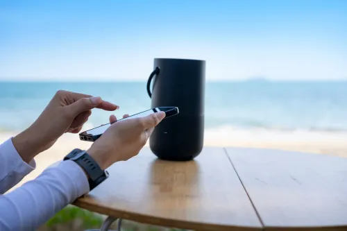 Portabler Lautsprecher auf Tisch mit Handy bedient