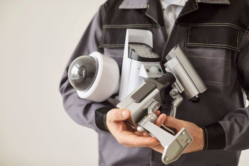 Person mit verschiedenen Kameras im Arm